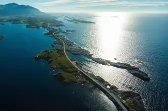 The famous Atlantic Road, as featured in 007 movie No Time To Die, skips from skerry to skerry to link Kårvåg on the island of Averøya to Vevang on the mainland