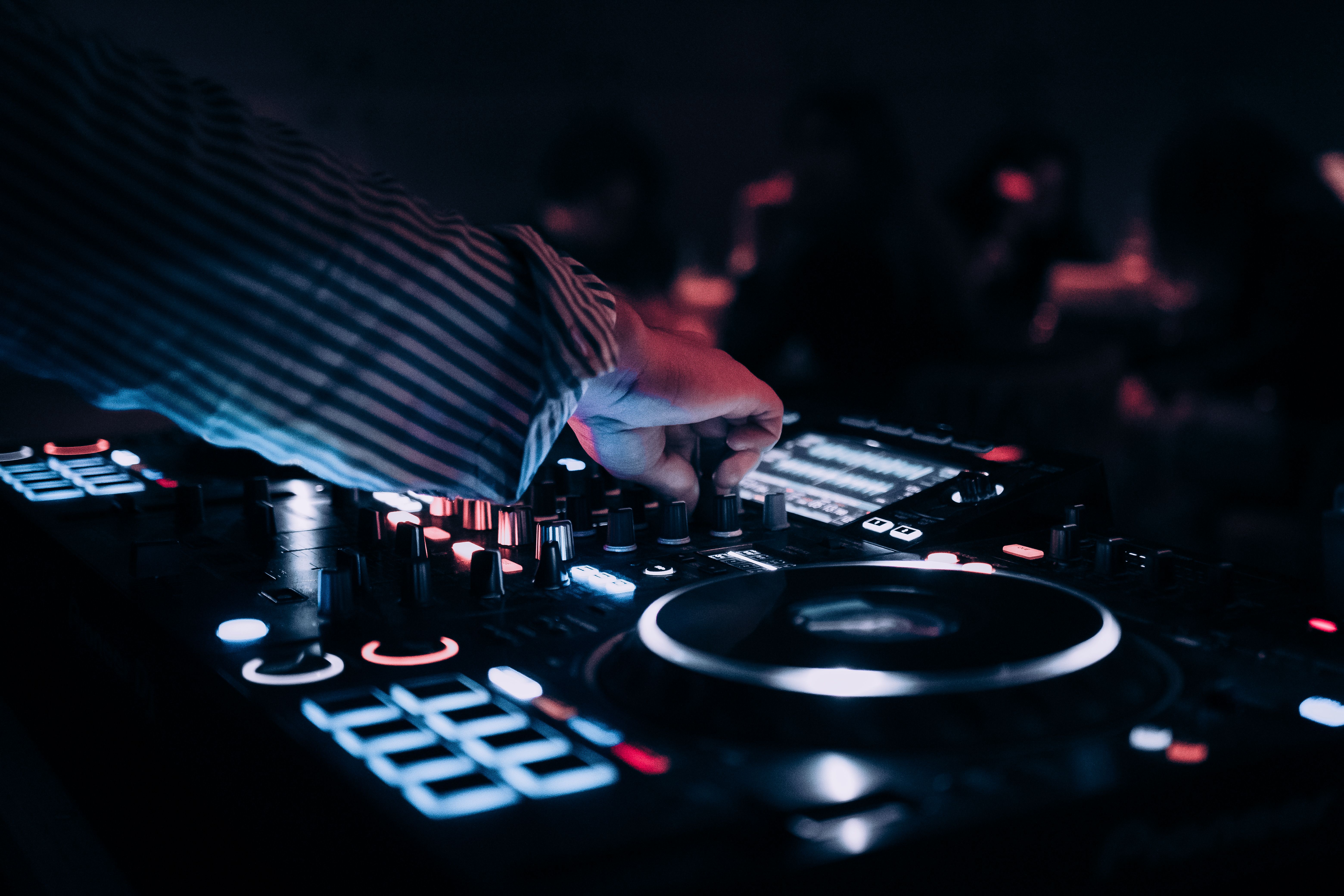 A DJ mixing music on a modern electronic deck