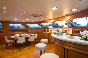 A corridor to starboard leads past the raised pilothouse to the bar and dining area forward