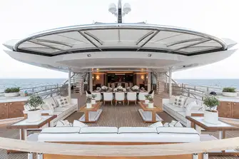 Open-air dining and lounging space on the upper deck aft