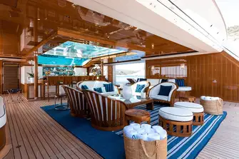 The beach club on the 96.6m (316.8ft) Feadship FAITH, for charter with Burgess, opens on three sides and sits beneath a glass-bottomed pool