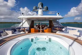 Looking aft on the large sun deck from the jacuzzi forward there is lounge seating on sun and shade, served by a bar under the hardtop, and versatile space aft