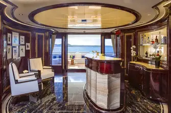 Just inside from the main deck aft is this sumptuous bar with bookedmatched American cherrywood, backlit onyx and marbles