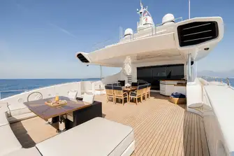 The main deck aft has built-in sun lounge seating and open-air dining