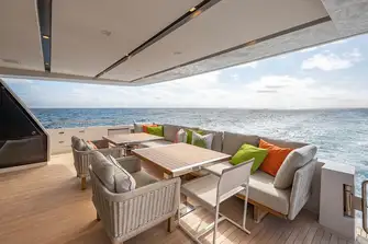 Open-air dining on the main deck aft, with steps either side leading down to the swim platform and tender garage
