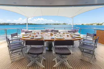 Open air dining and a sun lounge on the bridge deck aft