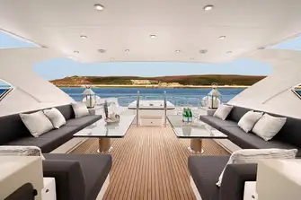 Looking aft on the sun deck past the BBQ and bar to port, lounge seating, jacuzzi and deck crane