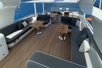 Looking aft on the flybridge, across the large lounge with informal open-air dining, and a bar and sun lounge on the lower level