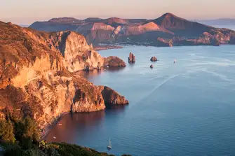 Sunset on the cliffs and the island of Vulcano visible in the background