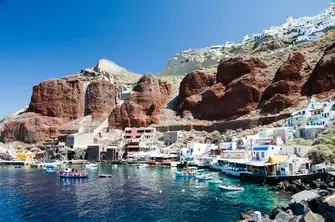 Ammoudi is a lively fishing village at the foot of the distinctive red cliffs below the historic town of Oia, Santorini